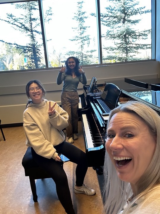Dr. Lana Henchell with two piano students.